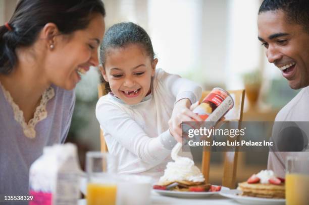 parents watching daughter putting whipped cream on pancakes - cream dairy product 個照片及圖片檔