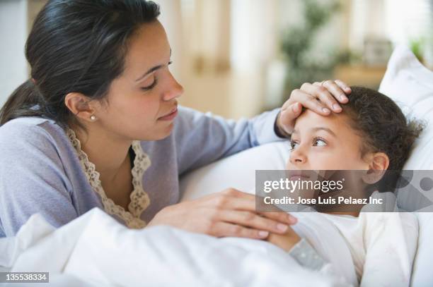 hispanic mother comforting sick child - sick kid fotografías e imágenes de stock