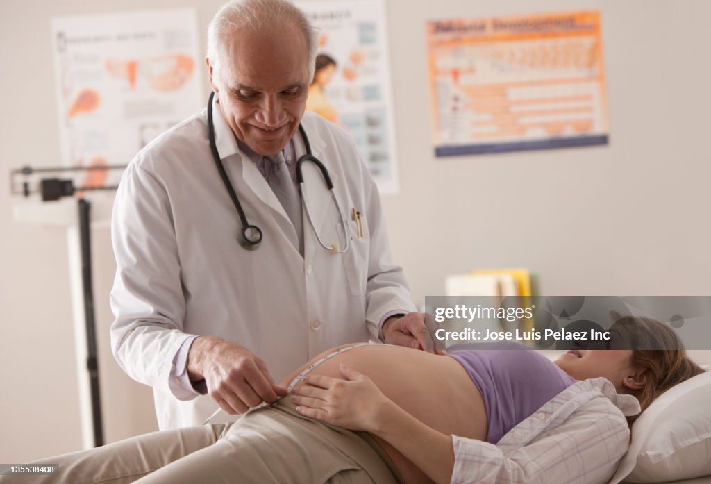 Doctor measuring pregnant woman's stomach