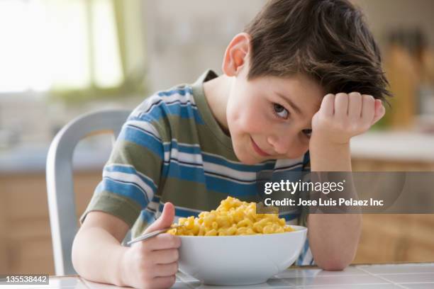 caucasian boy eating macaroni and cheese - pasta geniessen stock-fotos und bilder