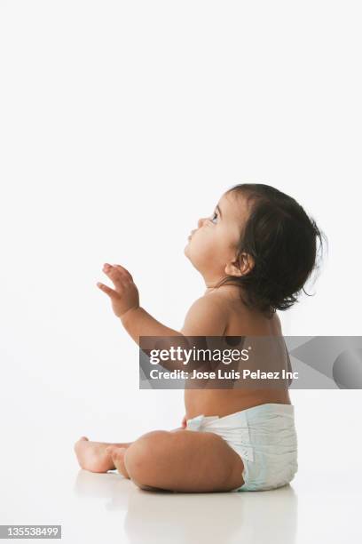 hispanic baby girl sitting on floor - girl sitting on floor stock-fotos und bilder