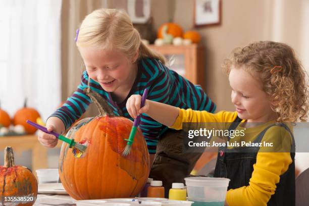 caucasian girls painting pumpkin - pumpkin decorating stock pictures, royalty-free photos & images