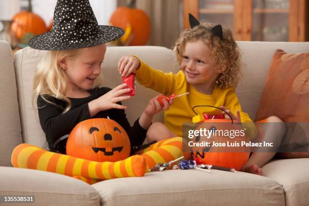 caucasian girls in halloween costumes eating candy - halloween candy stock pictures, royalty-free photos & images