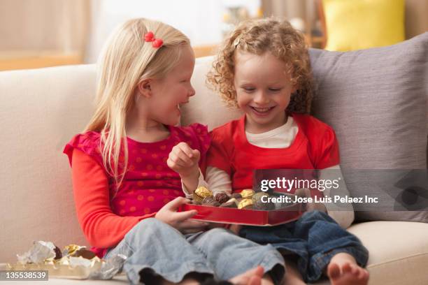 caucasian girls eating valentine's candy - sharing chocolate stock-fotos und bilder