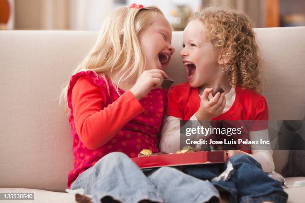 caucasian girls eating valentine's candy - chocolate heart stockfoto's en -beelden