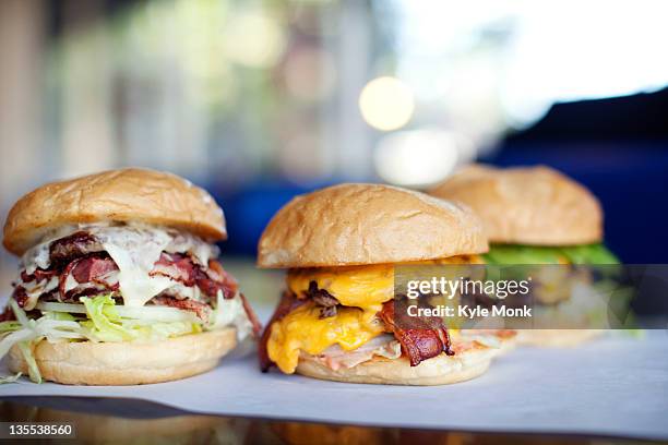 various indulgent cheeseburgers in diner - american burger stock-fotos und bilder