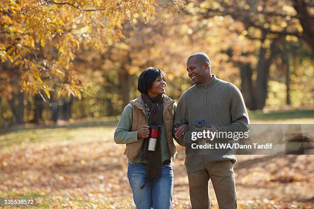 black couple walking together in park in autumn - african american couple walking park ストックフォトと画像