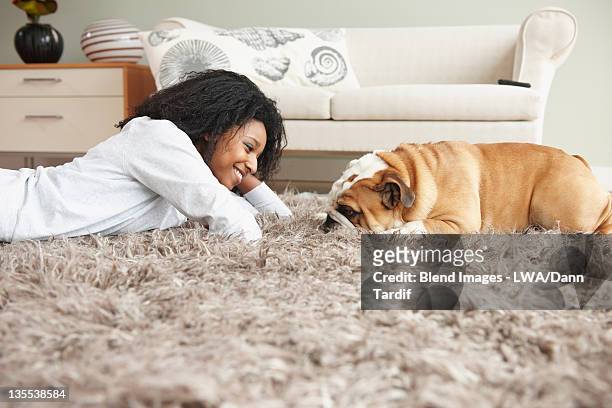 black woman laying on floor with dog - ラグ ストックフォトと画像