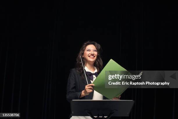 smiling mixed race conductor holding folder - conductor's baton stock pictures, royalty-free photos & images