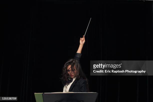 mixed race conductor pointing baton - conductor's baton stock pictures, royalty-free photos & images