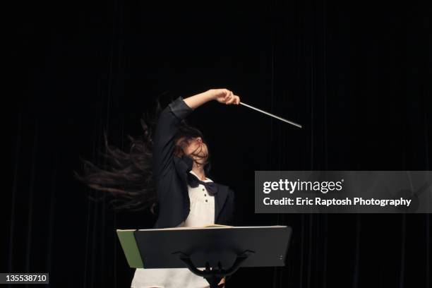 mixed race conductor pointing baton - music conductor stock pictures, royalty-free photos & images