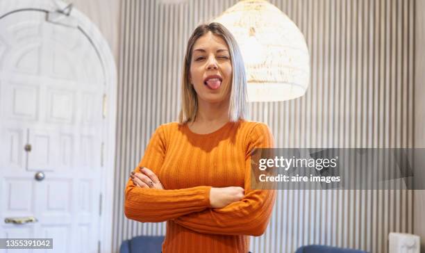 young woman posing with crossed arms sticking out tongue looking at camera - young woman gray hair stock pictures, royalty-free photos & images