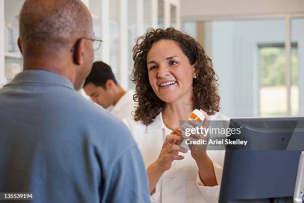 pharmacist talking to customer about prescription - female with group of males stock pictures, royalty-free photos & images