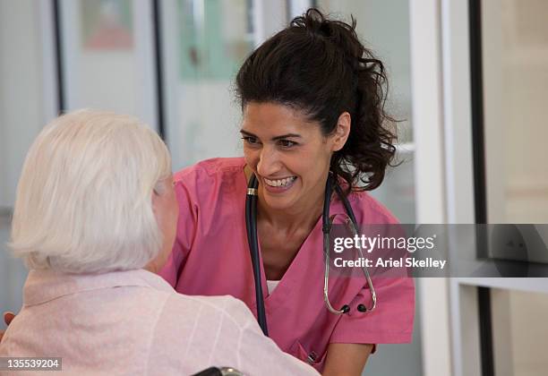 nurse reassuring patient in wheelchair - sobre os ombros - fotografias e filmes do acervo