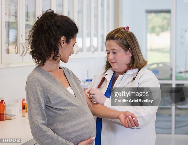 pregnant woman having blood test in doctor's office - blood testing photos et images de collection