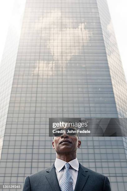 black businessman standing near highrise - black suit sunglasses stock pictures, royalty-free photos & images