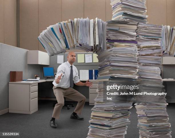 mixed race businessman facing paperwork monster - large office stock pictures, royalty-free photos & images