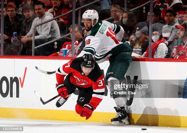 Pavel Zacha of the New Jersey Devils is hit by Jordan Greenway of the Minnesota Wild in the second period at Prudential Center on November 24, 2021...