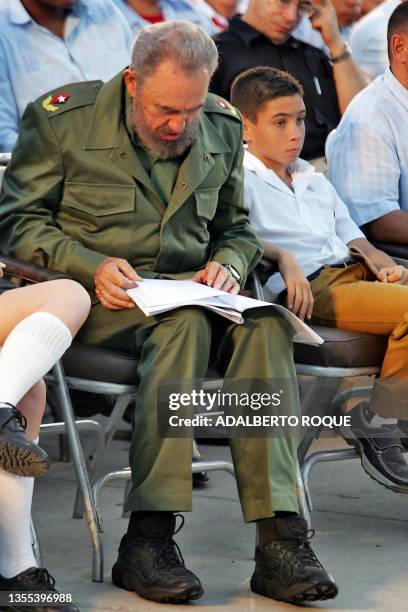 Cuban President Fidel Castro reads documents while Elian Gonzalez looks on, during a political meeting, 06 December 2005 in Cardenas city, province...