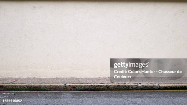 empty and clean wall, sidewalk and street in paris - wall foto e immagini stock