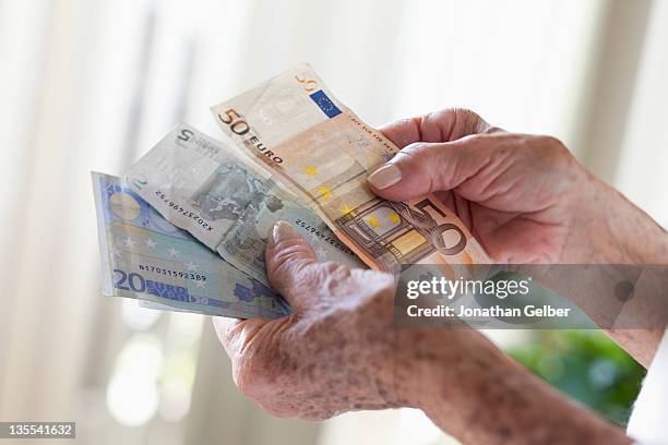 detail of a senior woman holding european banknotes - nota de euro da união europeia imagens e fotografias de stock