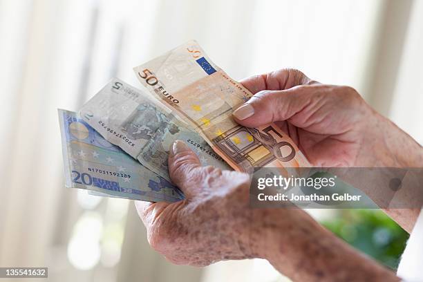 detail of a senior woman holding european banknotes - twenty euro note 個照片及圖片檔