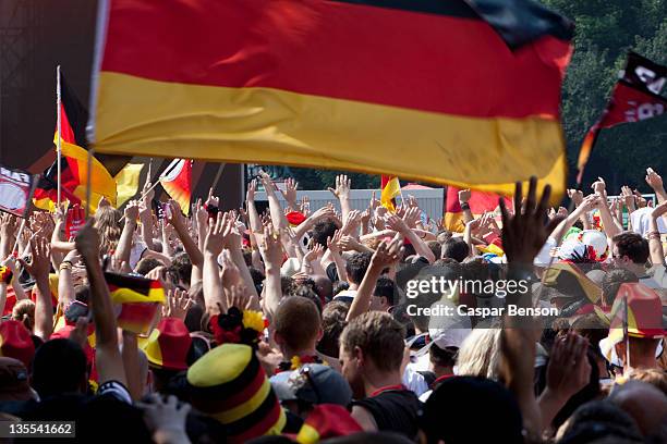 detail of people in a crowd cheering and waving german flags - deutsche kultur stock-fotos und bilder