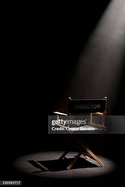 a spot lit directors chair - spot lit photos et images de collection