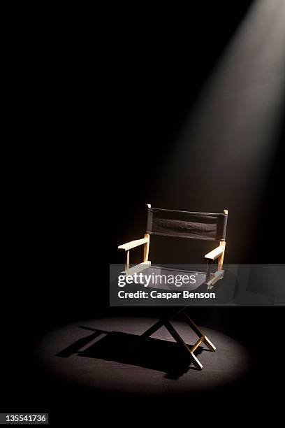 a spot lit directors chair - directors chair stock pictures, royalty-free photos & images