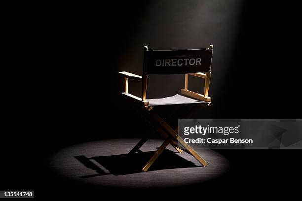 a spot lit directors chair - film set stock pictures, royalty-free photos & images