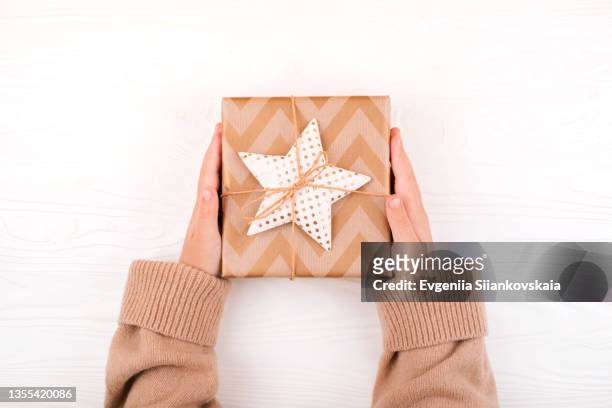 child's hands with christmas gift on white background. - hand sleeve stock pictures, royalty-free photos & images