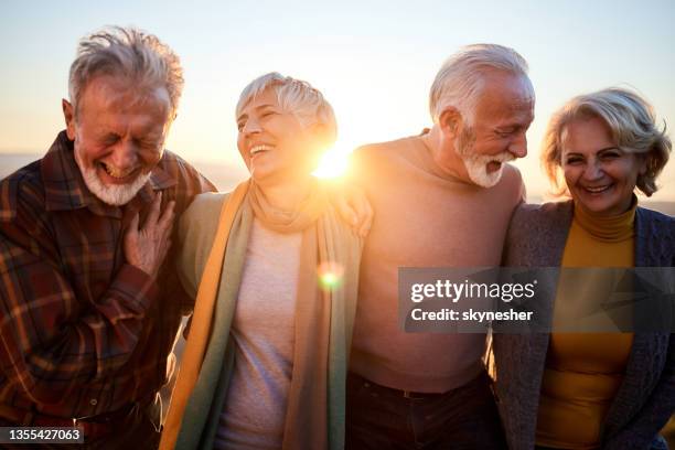 happy mature couples talking while walking in autumn day. - happy friends stockfoto's en -beelden