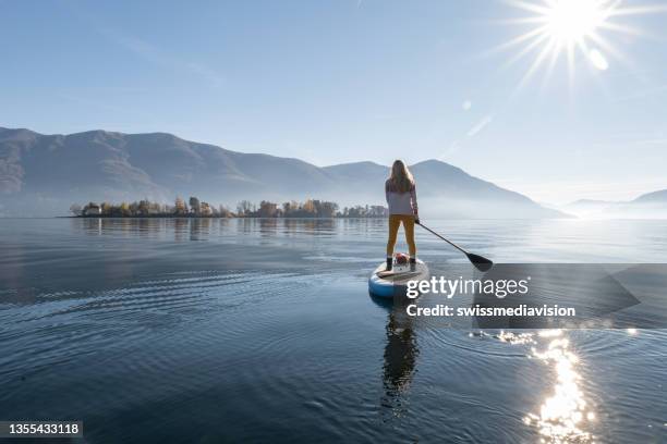 woman paddling on a stand up paddle board - paddle surf stock pictures, royalty-free photos & images