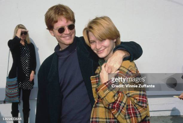 American actor Eric Stoltz with his arm around American actress Bridget Fonda as they attend the Hollywood premiere of 'Beauty and the Beast', held...