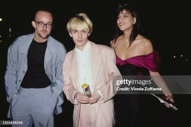 American artist Keith Haring , wearing a grey suit with a black t-shirt, British keyboard player and singer Nick Rhodes, wearing a pink suit with a...