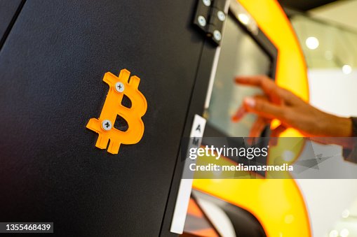 A person operates an ATM of bitcoins, one of the most popular cryptocurrencies in Valencia, Spain A person operates an ATM of bitcoins, one of the most popular cryptocurrencies in Valencia, Spain