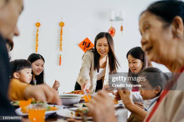 multi generation asian chinese family having chinese new year eve reunion dinner at home - 中國新年 個照片及圖片檔