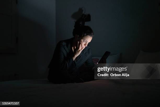 frau mit ihrem smartphone spät in der nacht. - bed phone stock-fotos und bilder