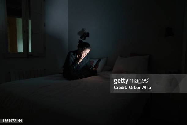woman using her smart phone late at night. - insomnia stockfoto's en -beelden
