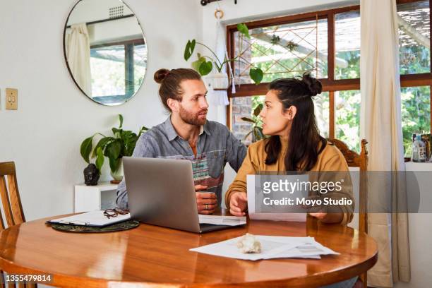 shot of a young couple using a laptop and checking their finances at home - exclusive preview of the steve gleason project in support of the fight against als stockfoto's en -beelden