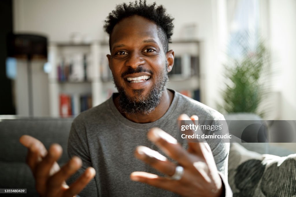 Lächelnder Mann mit Videoanruf von zu Hause