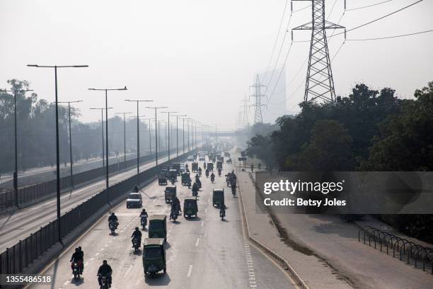People drive through smog on November 25, 2021 in Lahore, Pakistan. Last week, Lahore was the world's most polluted city, according to data from...