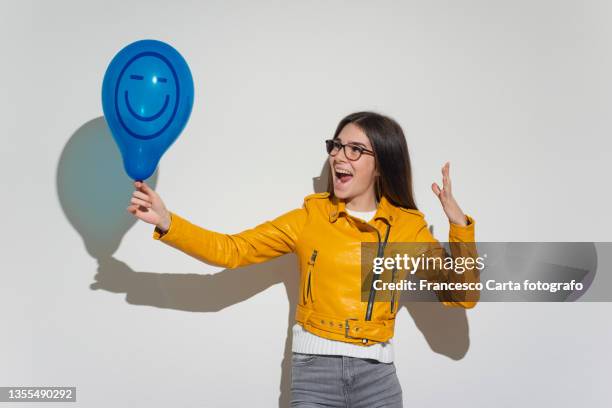 woman holds a balloon with an anthropomorphic face - faces smile celebrate stock pictures, royalty-free photos & images