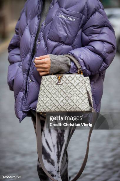 Sonia Lyson is seen wearing black boots Zara, purple down feather jacket Miu Miu, leggings H&M, sunglasses Dior, Louis Vuitton bag on November 24,...