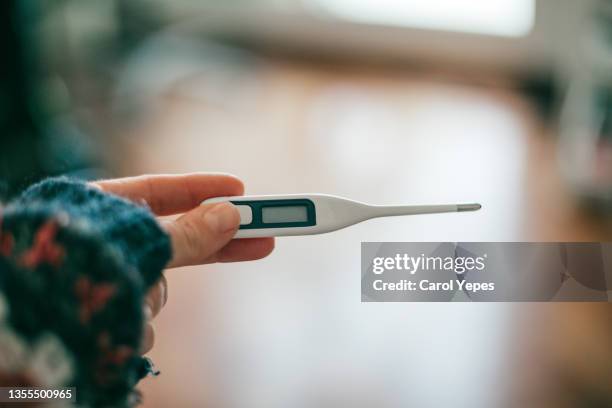 close-up of woman holding  digital thermometer - digital thermometer stock pictures, royalty-free photos & images