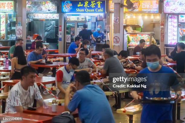 socially distanced diners at holland village hawker centre, singapore - market trader stockfoto's en -beelden