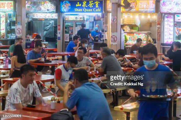 socially distanced diners at holland village hawker centre, singapore - dinner open cafe stock pictures, royalty-free photos & images