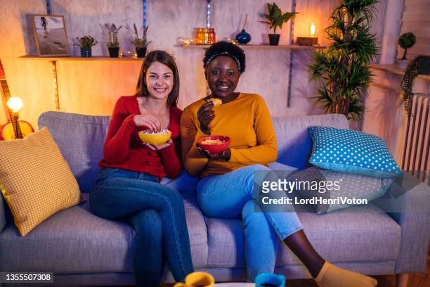 female friends relaxing together at home - binge watching stock pictures, royalty-free photos & images