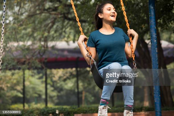 carefree woman enjoying swinging at park - using a swing stock pictures, royalty-free photos & images