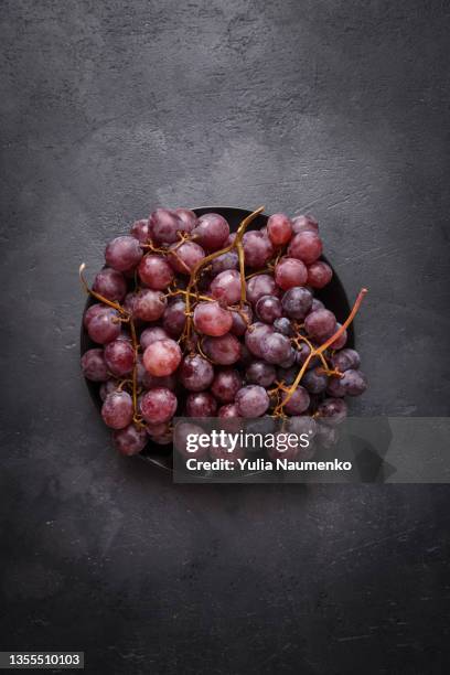 grapes on a dark stone table. fresh grape on black background. - uva fotografías e imágenes de stock